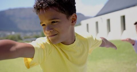 Joyful Biracial Boy Playing Outdoors in Sunny Grass