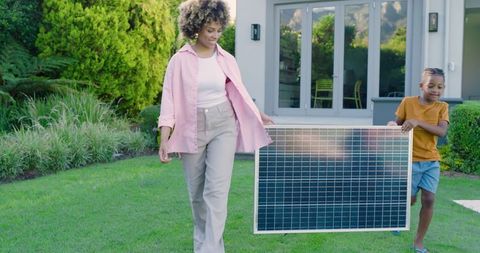 Mother and Son Carrying Solar Panel for Sustainable Living