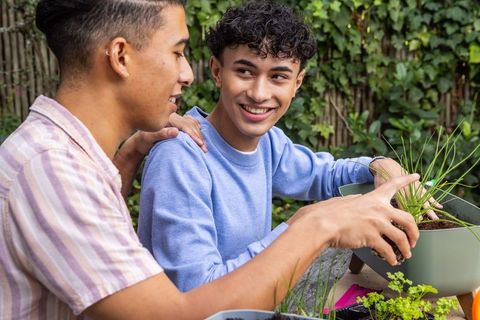Friends enjoying gardening together in backyard