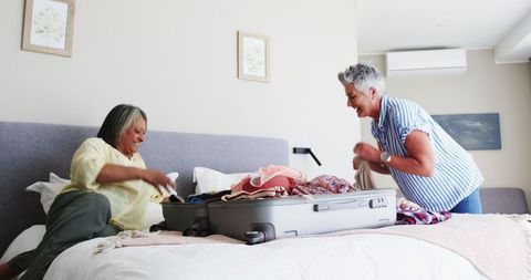 Senior Lesbian Couple Packing Luggage for Vacation