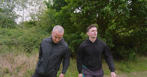 Two men enjoying nature walk in lush green forest