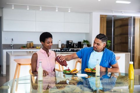 Diverse Couple Enjoying Burger Meal in Modern Kitchen
