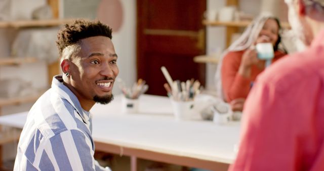 Cheerful Man Conversing in Pottery Studio with Friends - Download Free Stock Images Pikwizard.com