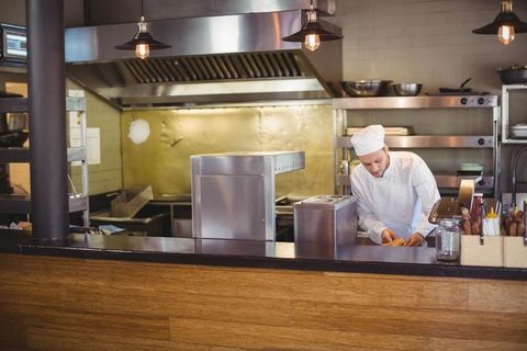 Professional Chef Preparing Meal in Industrial Restaurant Kitchen