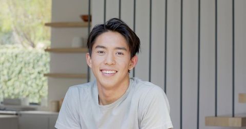 Smiling Young Man Relaxing in Minimalist Home Interior