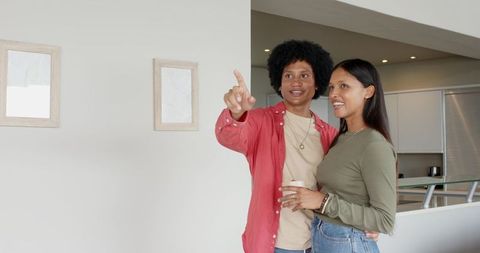 Diverse Couple in Modern Home Gesturing and Smiling