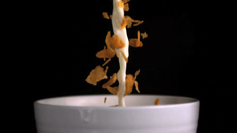 Slow Motion Pouring Milk and Cereal into White Bowl