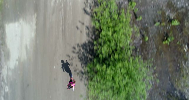 Aerial View of Person Jogging Alongside Lush Greenery on Empty Road - Download Free Stock Images Pikwizard.com