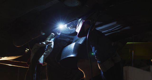 Mechanic Repairing Vehicle in Dark Garage with Flashlight - Download Free Stock Images Pikwizard.com