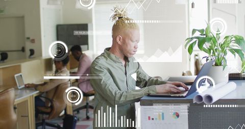Albino man analyzing data on laptop in modern office