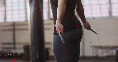 Athlete Skipping Rope in Gym with Punching Bag Background