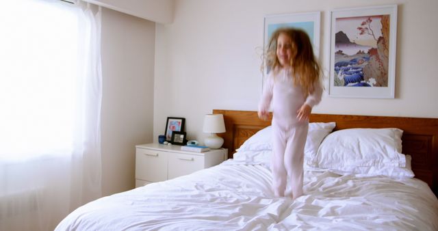 Joyful Child Jumping on Bed in Bright Sunlit Bedroom - Download Free Stock Images Pikwizard.com