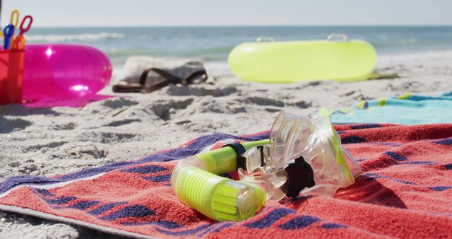 Image of snorkeling mask, towels and beach equipment lying on beach. Holidays, vacations, relax and beach concept.