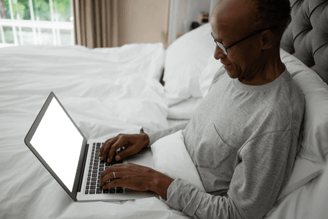 senior man using laptop while relaxing in cozy bed environment - Download Free Stock Videos Pikwizard.com