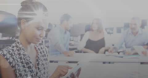 Businesswoman Using Tablet in Busy Office Environment