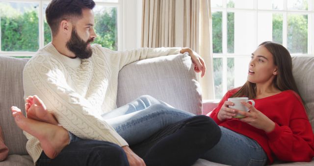 Image of happy caucasian couple siting on sofa and drinking coffee - Download Free Stock Photos Pikwizard.com