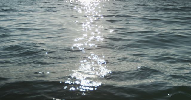 Sunlight reflected on rippled pattern of calm blue ocean. Nature, relaxation, travel, water transport and vacations.