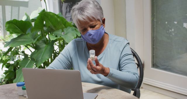 Senior Woman Using Laptop and Holding Medication Bottle at Home - Download Free Stock Images Pikwizard.com