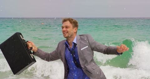 Businessman splashing in ocean with briefcase