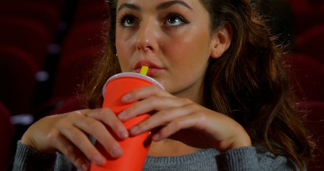 Woman enjoying beverage at movie theater - Download Free Stock Images Pikwizard.com