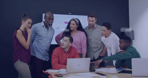 Multicultural Team Collaborating Around Laptop Reviewing Business Charts and Data