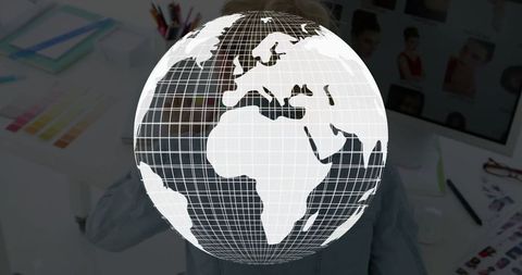 Floating wireframe globe above designer's desk illustrating global creativity