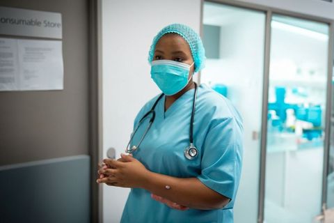 Healthcare Professional Prepares for Duties in Hospital Corridor