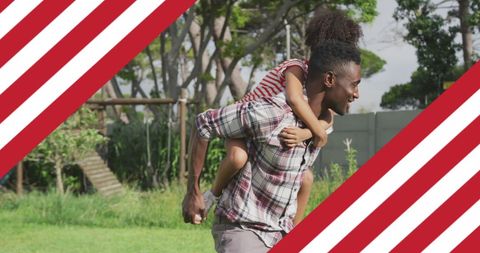 African American Father Piggybacking Daughter Outdoors