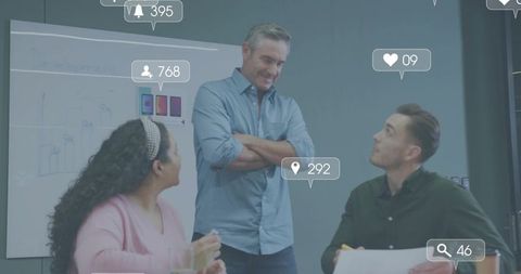 Manager leading creative team brainstorming with mobile mockups and social engagement icons