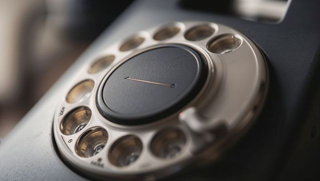 Vintage rotary telephone dial featuring central cap, numbered holes and chrome patina