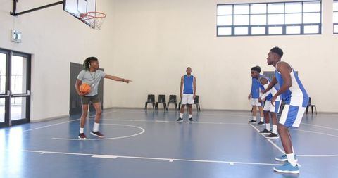 Diverse Male Basketball Players Dribbling on Indoor Court