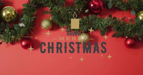 Merry christmas greeting with evergreen garland, gold and red baubles on scarlet