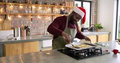 African American Man Wearing Santa Hat Glazing Homemade Cookies in Cozy Rustic Kitchen