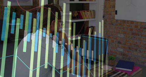 Businessman Analyzing Financial Charts on Laptop in Office