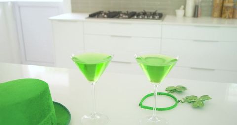 St patrick's day green martini cocktails on glossy white countertop with lucky shamrocks