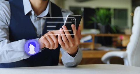 Professional holding smartphone scrolling messaging interface with chat overlay