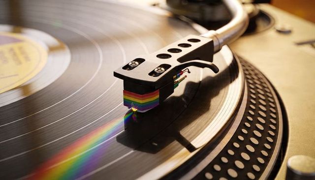 Spinning vinyl turntable stylus catching rainbow refraction warm retro macro music