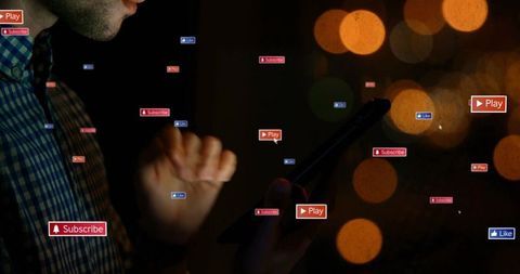 Person using tablet with floating social media icons at night