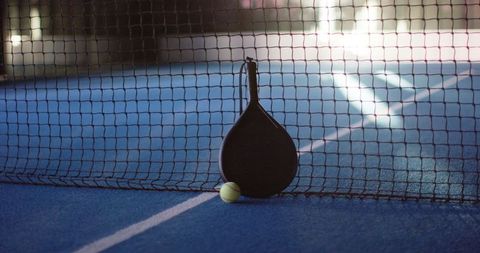 padel racket and tennis ball resting on blue court under net - Download Free Stock Images Pikwizard.com