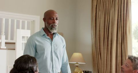 Smiling Man Engaging with Friends During Home Gathering