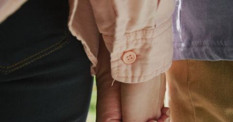 Close Up of Diverse Couple Holding Hands Outdoors on Sunny Day