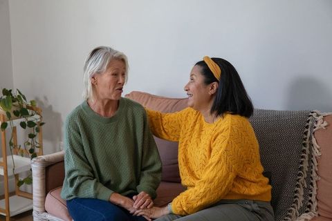 Diverse senior women sharing warm conversation and support on cozy sofa
