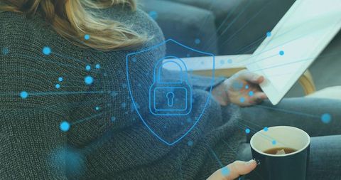 Woman holding tablet and mug on sofa with padlock shield overlay for home digital privacy
