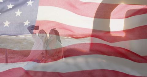 American Flag Overlay on Women Taking Selfie by Beach