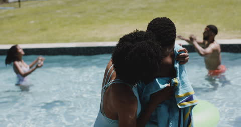Mother Drying Son by Poolside in Sunny Garden