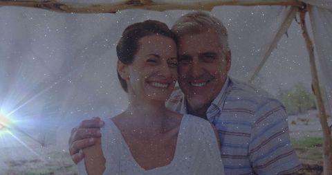 Happy mid adult couple embracing under lakeside canopy