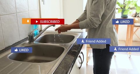 Woman washing hands in kitchen with social media alerts overlay