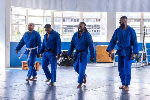 Four African American Martial Artists in Blue Uniforms Training Together
