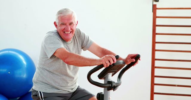Elderly man using the exercise bike at the gym