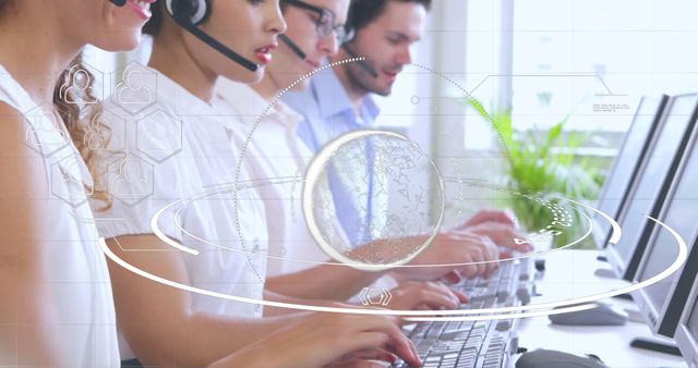 Customer service representatives seen working diligently at their computers in a well-lit office environment. They are wearing headsets and focused on their tasks. Great for use in materials related to customer support, business operations, teamwork, and communication technology.